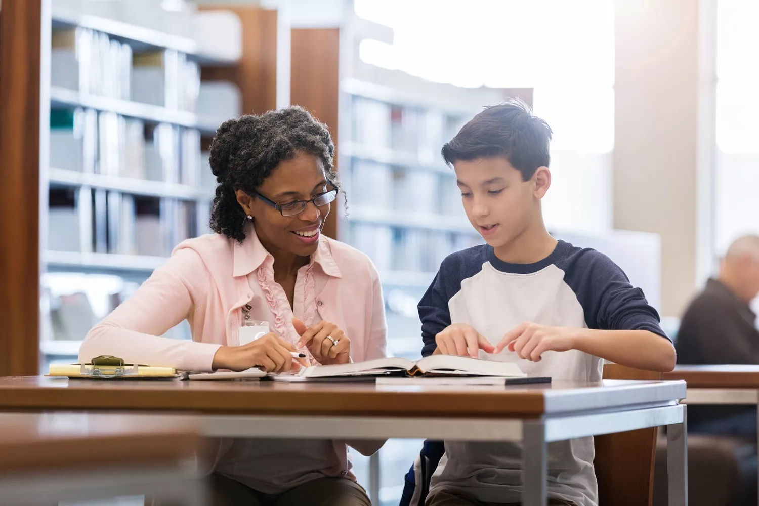 An advocate helping a foster student in a library