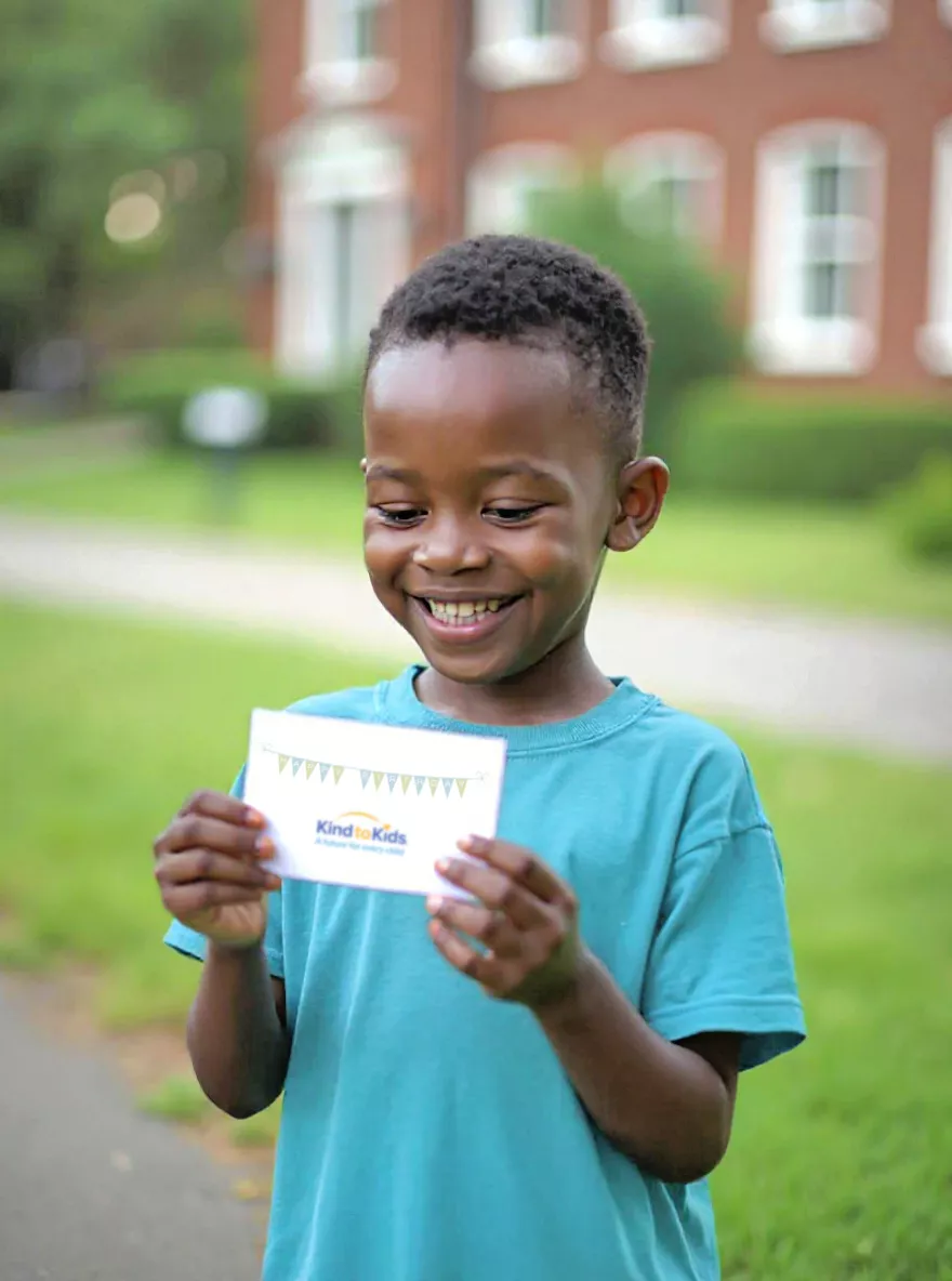 Child smiling and holding a birthday card