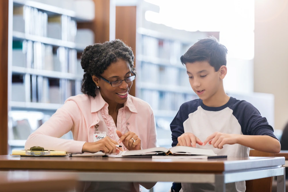 An advocate helping a foster student in a library